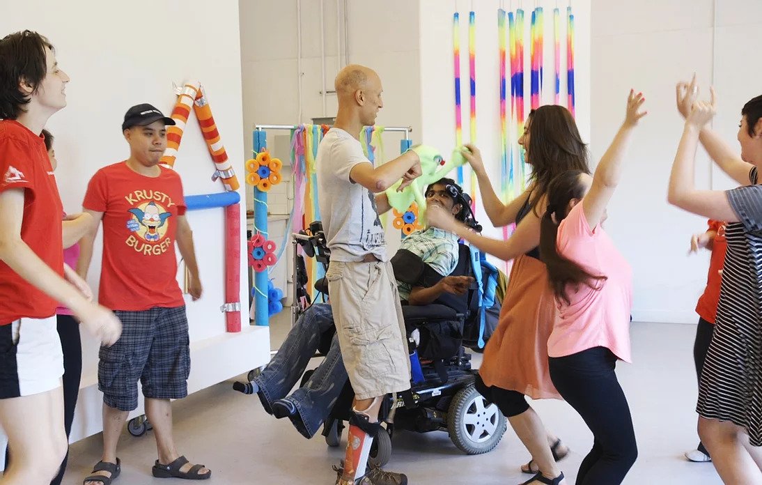 A group of people dancing in a room at a Purple Carrots workshop
