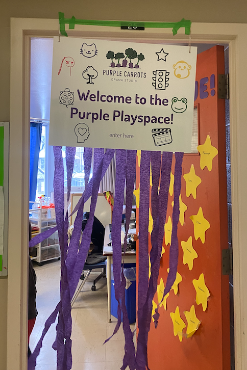 a welcome sign hangs from the front door of a classroom