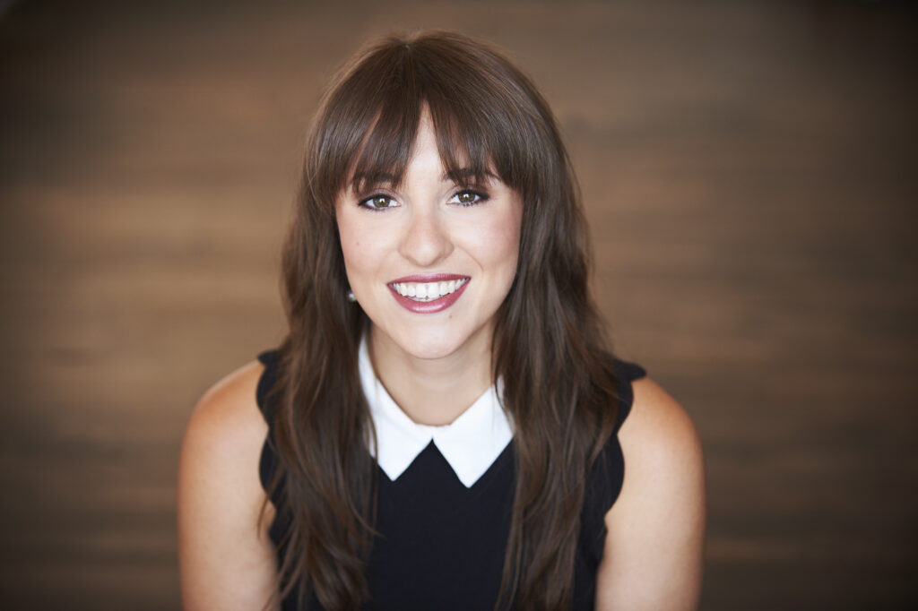 a woman with long brown hair wearing a black and white shirt